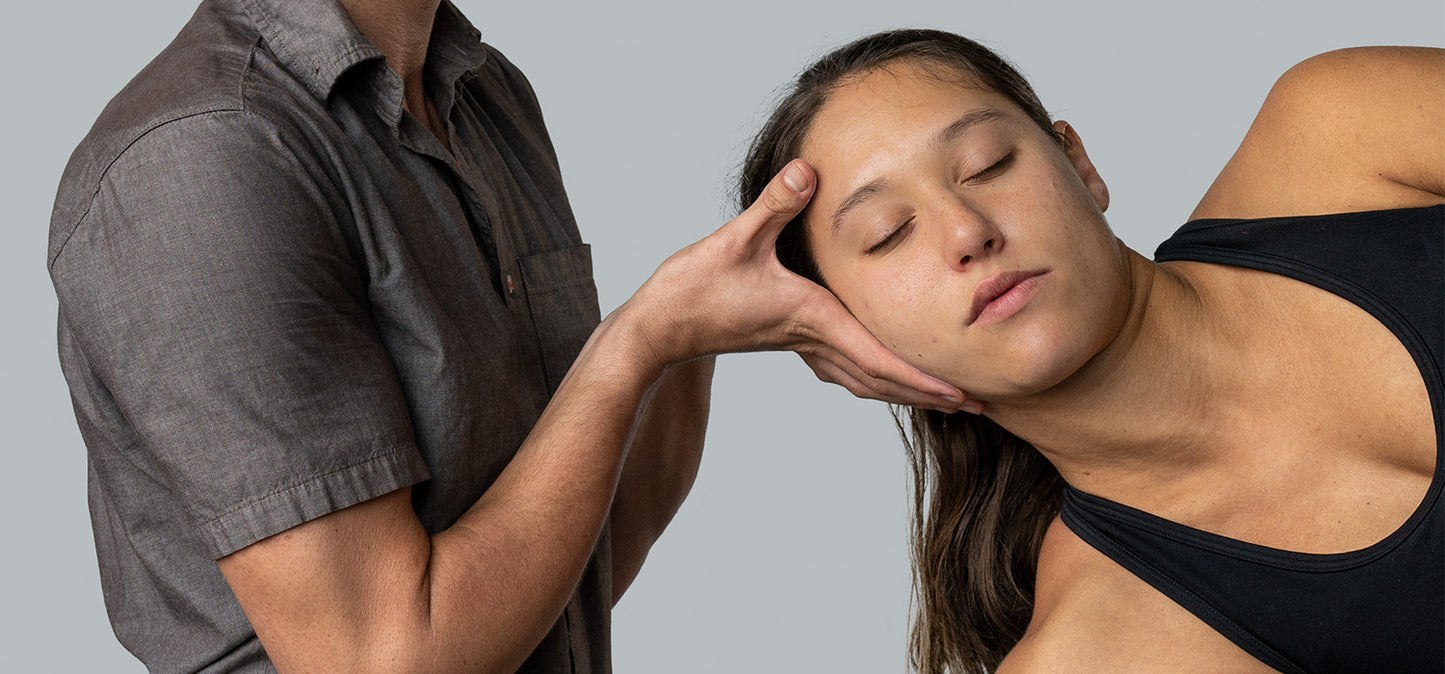 upper torso and hands of Matthew supporting the head of female patient during AIS therapy