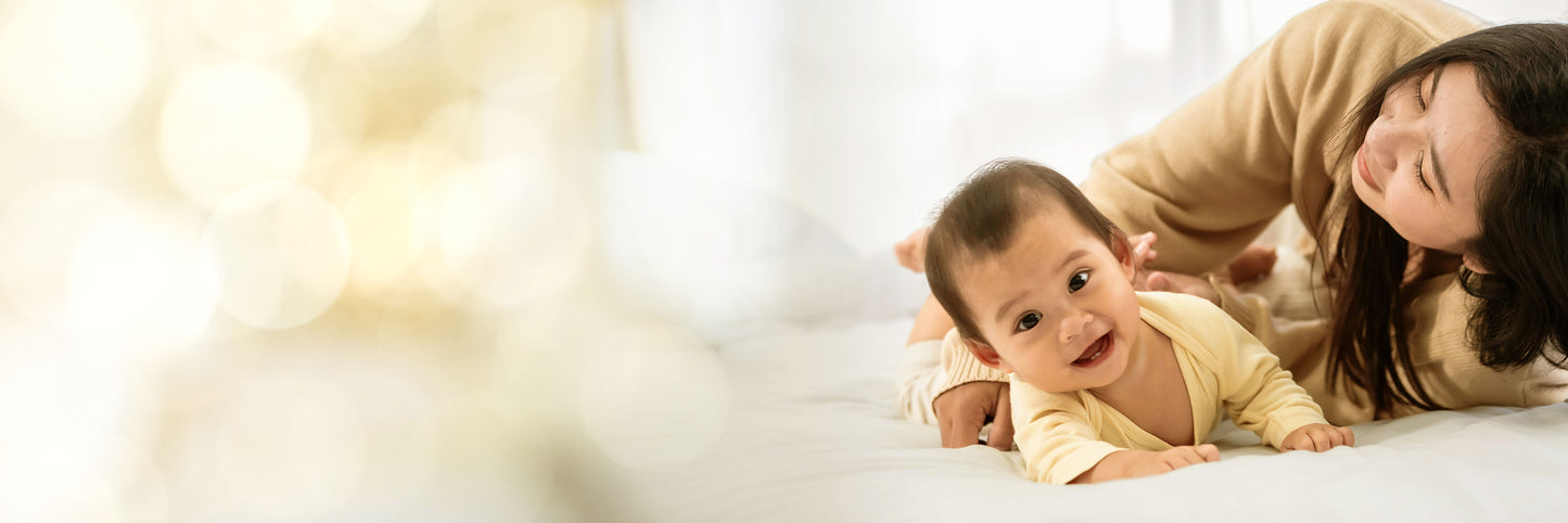 asian woman lying on the floor next to her asian baby