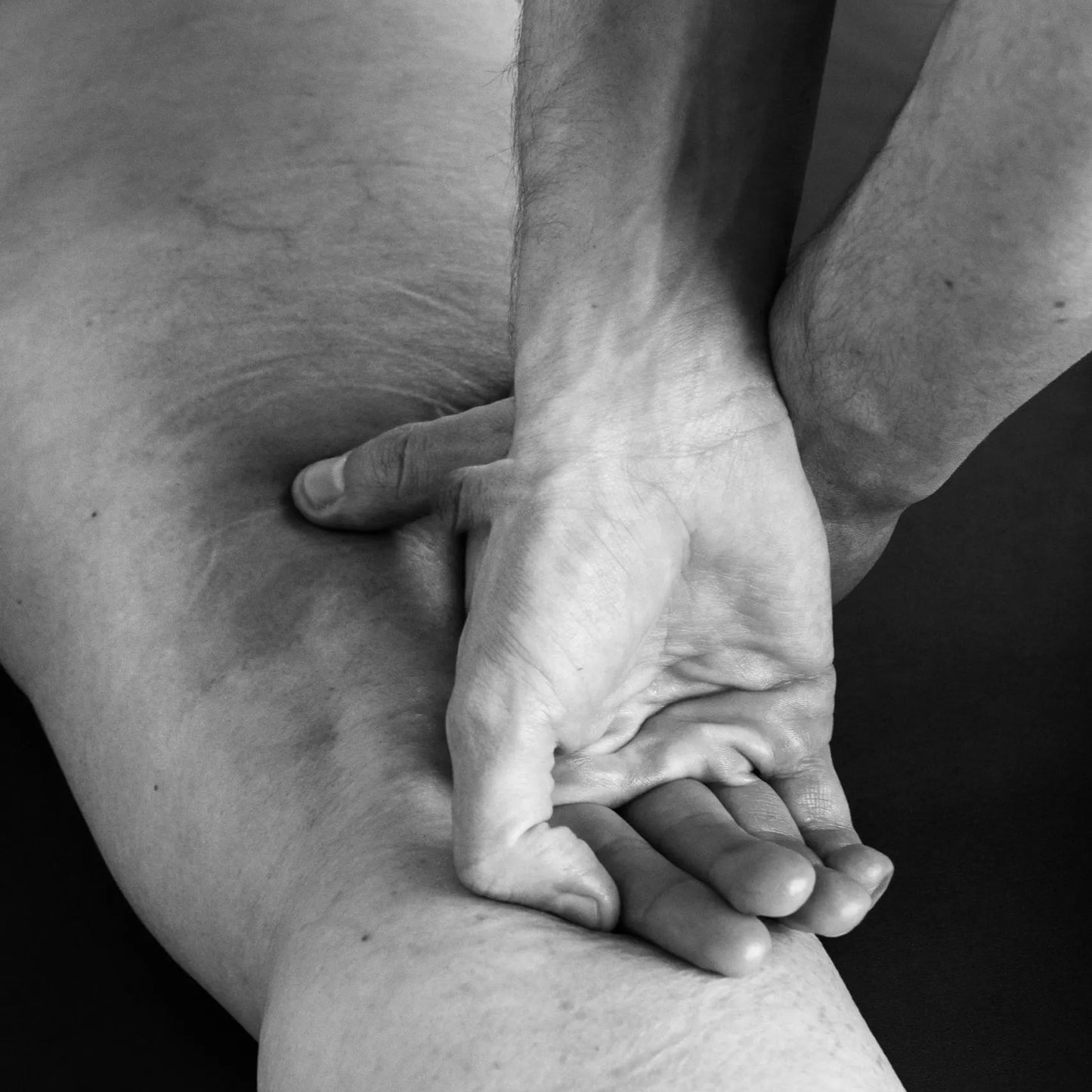 close-up of hand of Matthew Doolin performing bodywork on patient's thigh